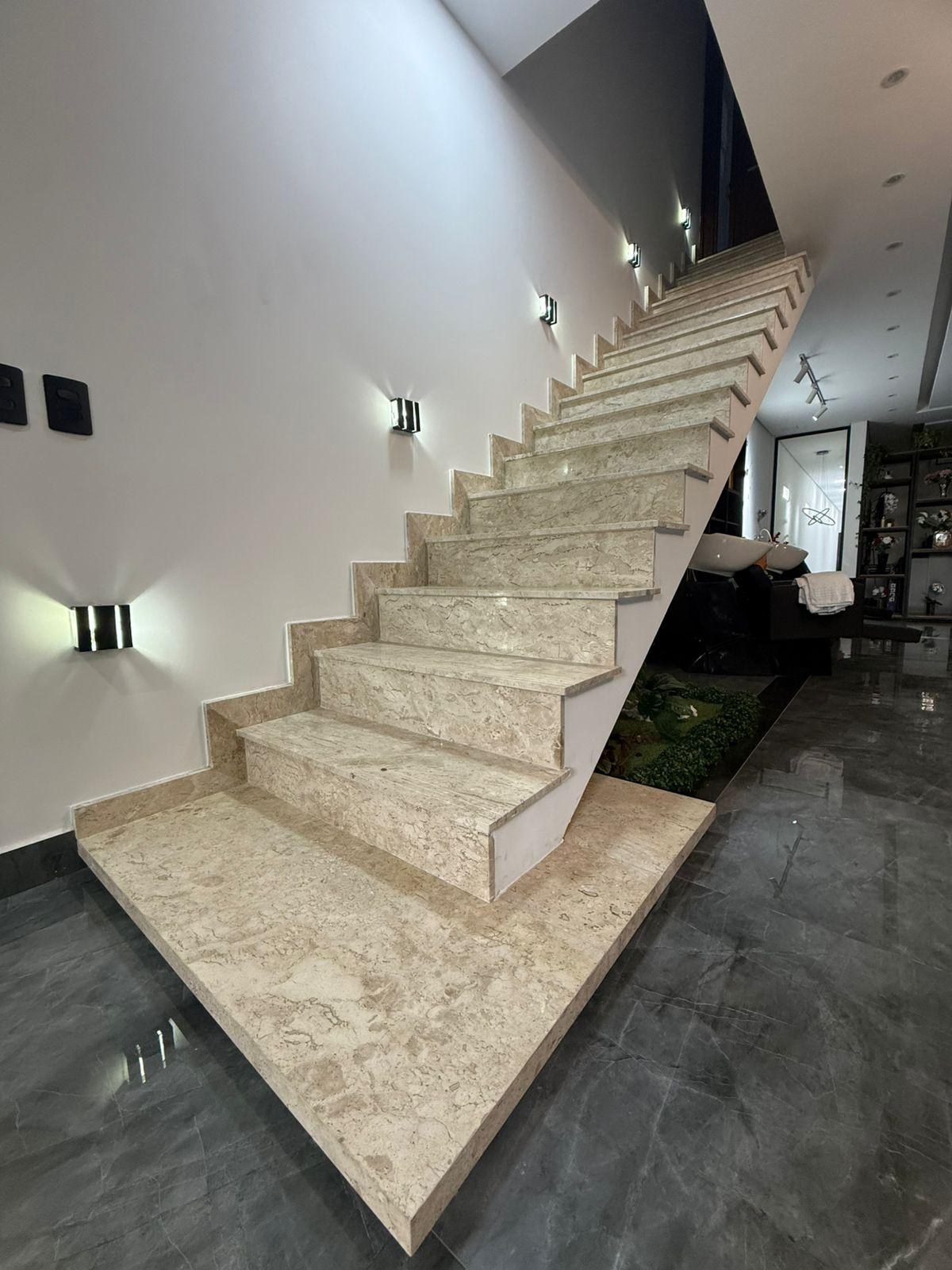 Escada em pedra bege com iluminação lateral