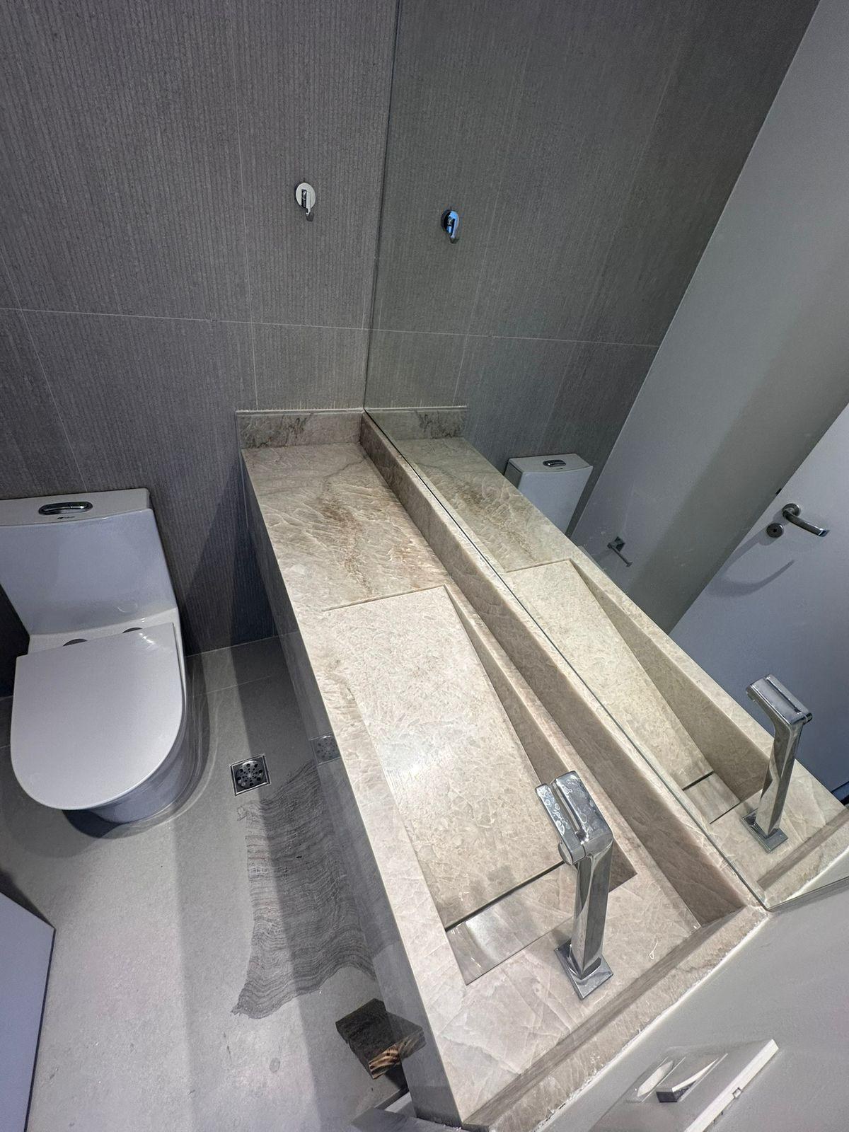 Lavabo com cuba esculpida e acabamento em pedra natural
